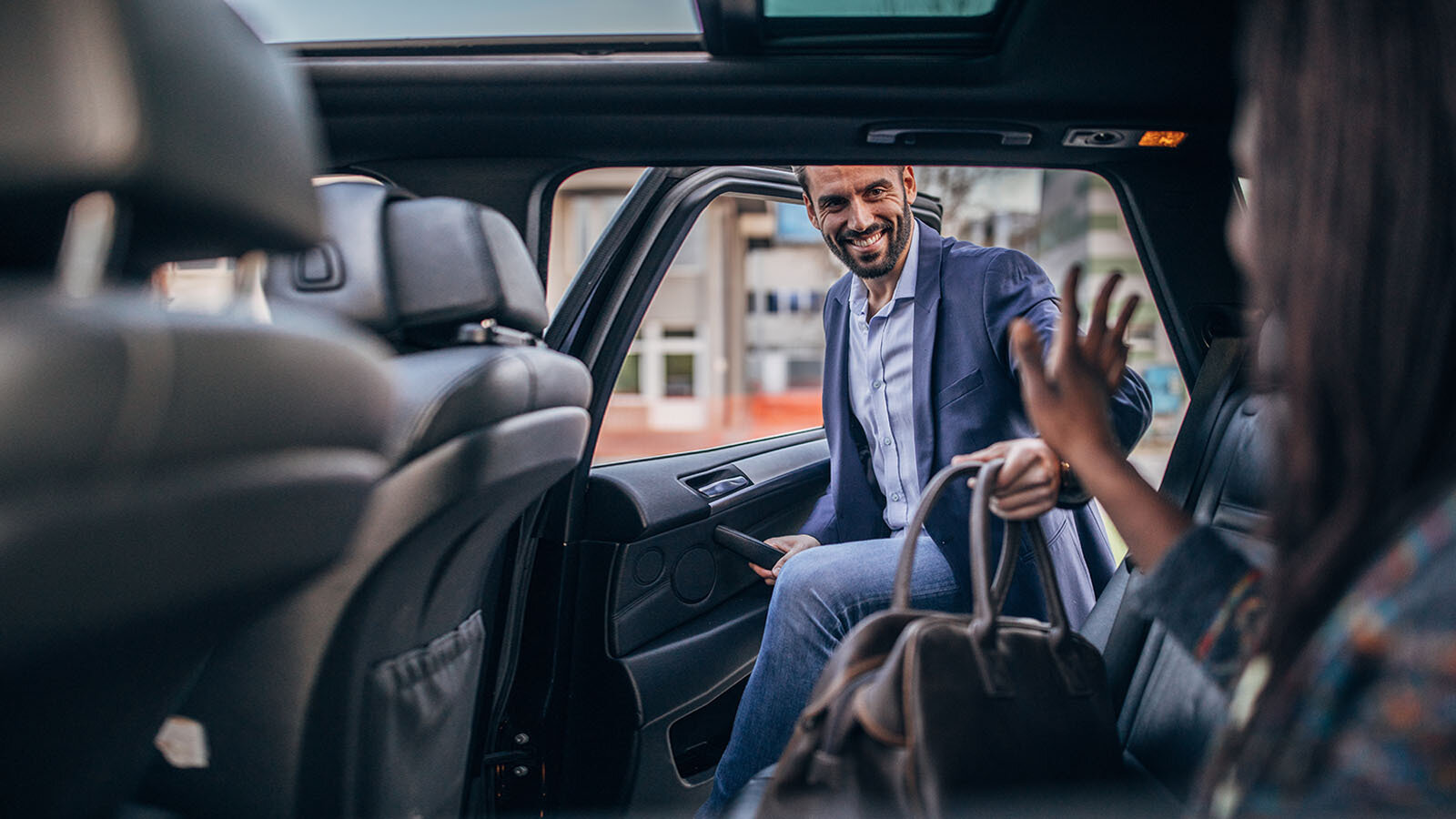 Hombre sonriente subiendo a un auto