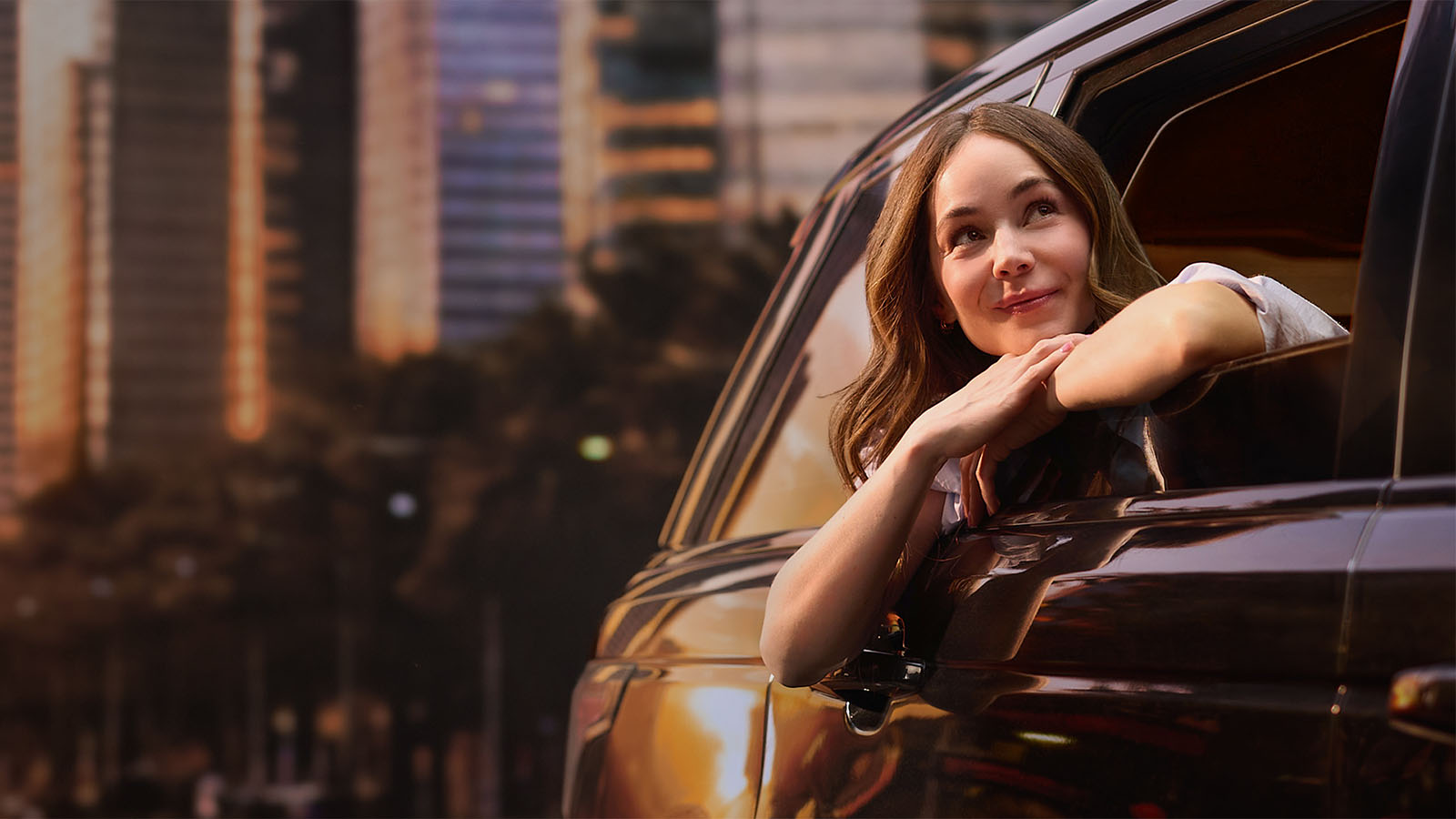 Camila Sodi asomada por la ventanilla de un auto en un atardecer