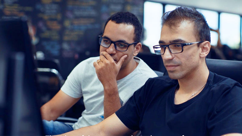 Two Trigg employees sitting in front of a computer.